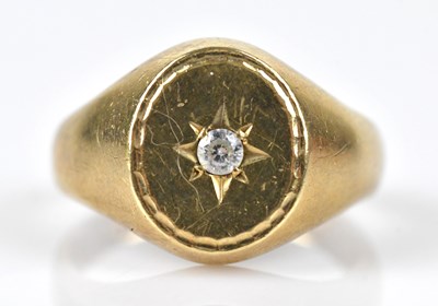 Lot 523 - A yellow metal signet ring set with a round...