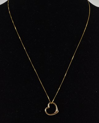 Lot 1383 - A 9ct yellow gold open heart pendant, on a 9ct...