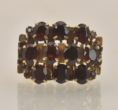 Lot 1312 - A yellow metal garnet set cluster ring, set...