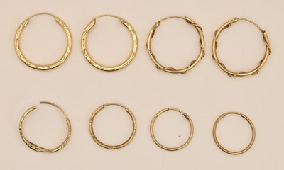 Lot 1391 - Eight assorted yellow metal hoop earrings...
