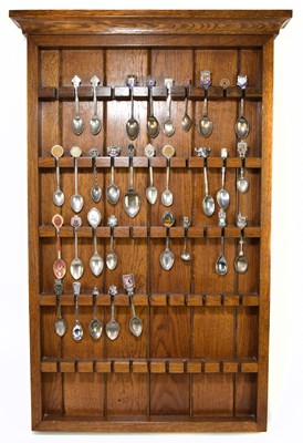Lot 1180 - An oak spoon rack containing a collection hallmarked silver and silver plated spoons