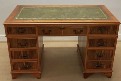Lot 704 - A reproduction kneehole pedestal desk with a...