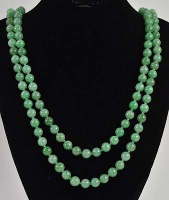 Lot 1376 - A single strand apple green jade bead necklace,...