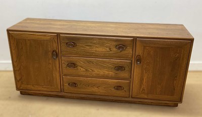 Lot 660 - ERCOL; a solid elm Windsor sideboard, with...