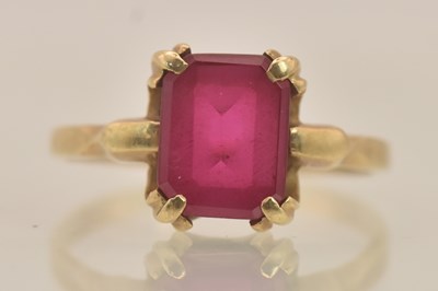 Lot 1304 - A yellow metal ruby set solitaire ring, the...