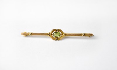 Lot 992 - A yellow metal bar brooch set with peridot...