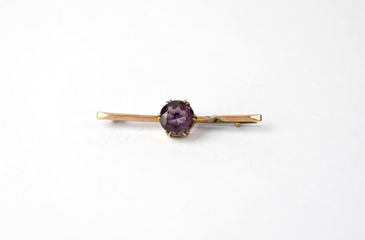 Lot 995 - A 9ct rose gold bar brooch set with central...