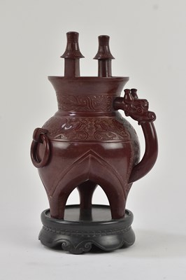 Lot 1051 - A Chinese carved maroon hardstone twin handled...