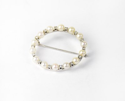 Lot 991 - An 18ct white gold circular brooch set with...