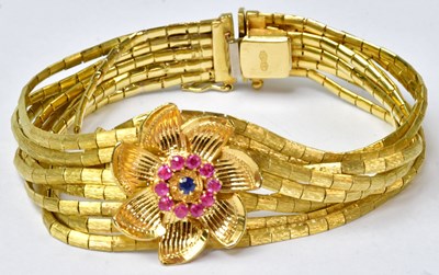 Lot 898 - A yellow metal nine-strand bracelet with...