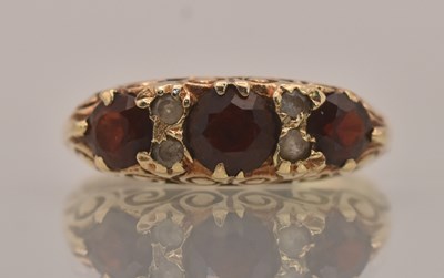 Lot 1330 - A 9ct yellow gold three stone garnet and tiny...