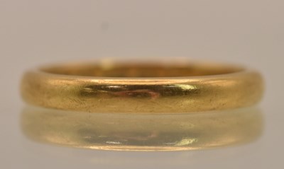 Lot 1310 - A 22ct yellow gold thin band ring, size K,...
