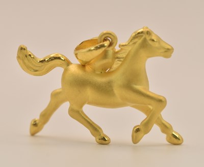Lot 1372 - A gold running horse pendant with matt finish,...