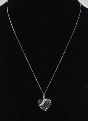 Lot 1380 - A 9ct white gold heart shaped pendant set with...