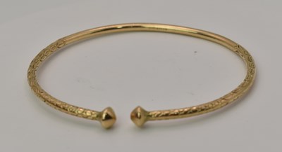 Lot 439 - A 9ct yellow gold torque bangle with acorn...