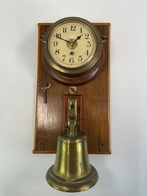 Lot 111 - A ship's clock and bell mounted on an oak...