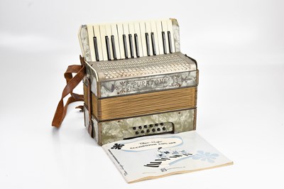 Lot 2192 - PURATONE; an accordion, with a music book.