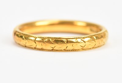 Lot 448 - A 22ct yellow gold wedding band with engraved...