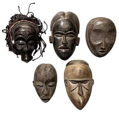 Lot 1010 - Five African tribal carved wooden masks,...