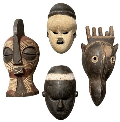 Lot 1008 - Four African carved wooden tribal masks,...
