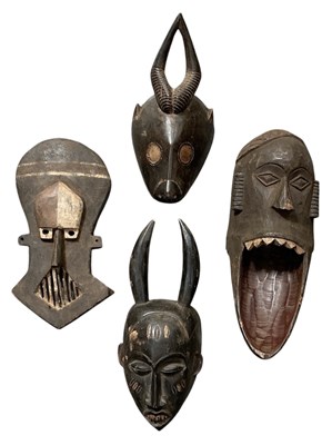 Lot 1009 - Four African carved wooden tribal masks,...