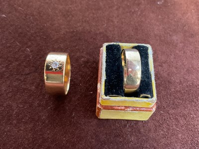 Lot 561 - An 18ct yellow gold broad wedding band set...