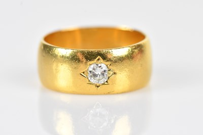 Lot 385 - A 22ct yellow gold diamond set broad ring, the...
