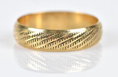 Lot 554 - A 9ct textured yellow gold wedding band, size...