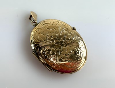Lot 934 - A 9ct yellow gold oval locket with floral...