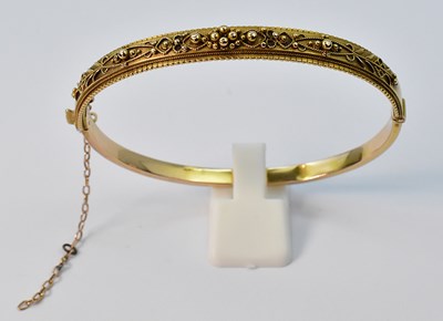 Lot 899 - A 15ct yellow gold hinged bangle, one half...