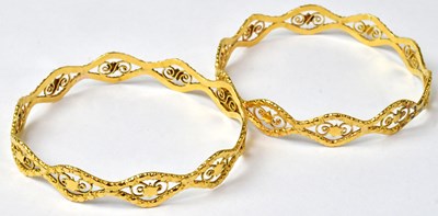 Lot 896 - A pair of Indian yellow metal bangles with...