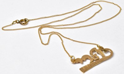 Lot 931 - A stylised script pendant on fine curb link...