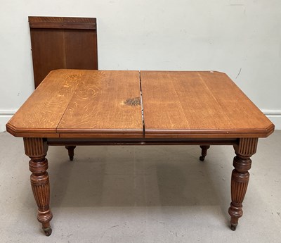 Lot 61 - An Edwardian oak extending dining table, with...