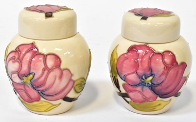 Lot 136 - MOORCROFT; a pair of 'Magnolia' pattern lidded...