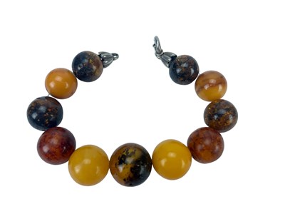 Lot 909 - A bracelet with amber beads and white metal...