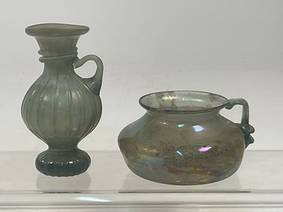 Lot 14 - An iridescent Roman glass vessel of squat form...