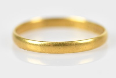 Lot 585 - A yellow metal wedding band, size K, unmarked,...
