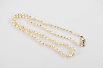 Lot 943 - A single-strand pearl necklace with a 14ct...