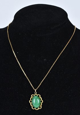 Lot 337 - A Chinese green hardstone pendant, suspended...