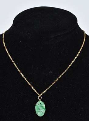 Lot 343 - A Chinese green hardstone pendant in yellow...