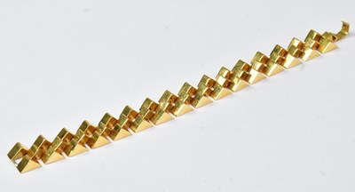 Lot 895 - A yellow metal bracelet comprising three rows...