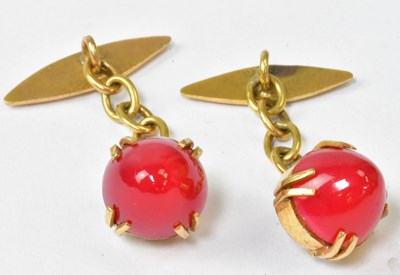 Lot 956 - A pair of yellow metal cufflinks set with red...