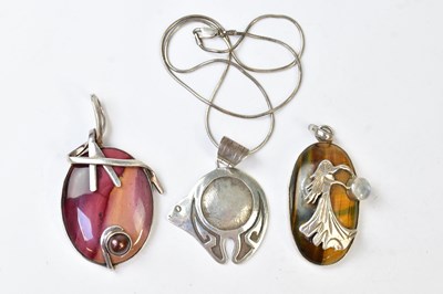 Lot 947 - Three pendants, comprising a tiger's eye set...
