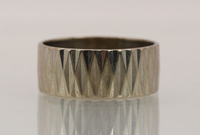 Lot 1365 - An 18ct white gold band ring, with textured...