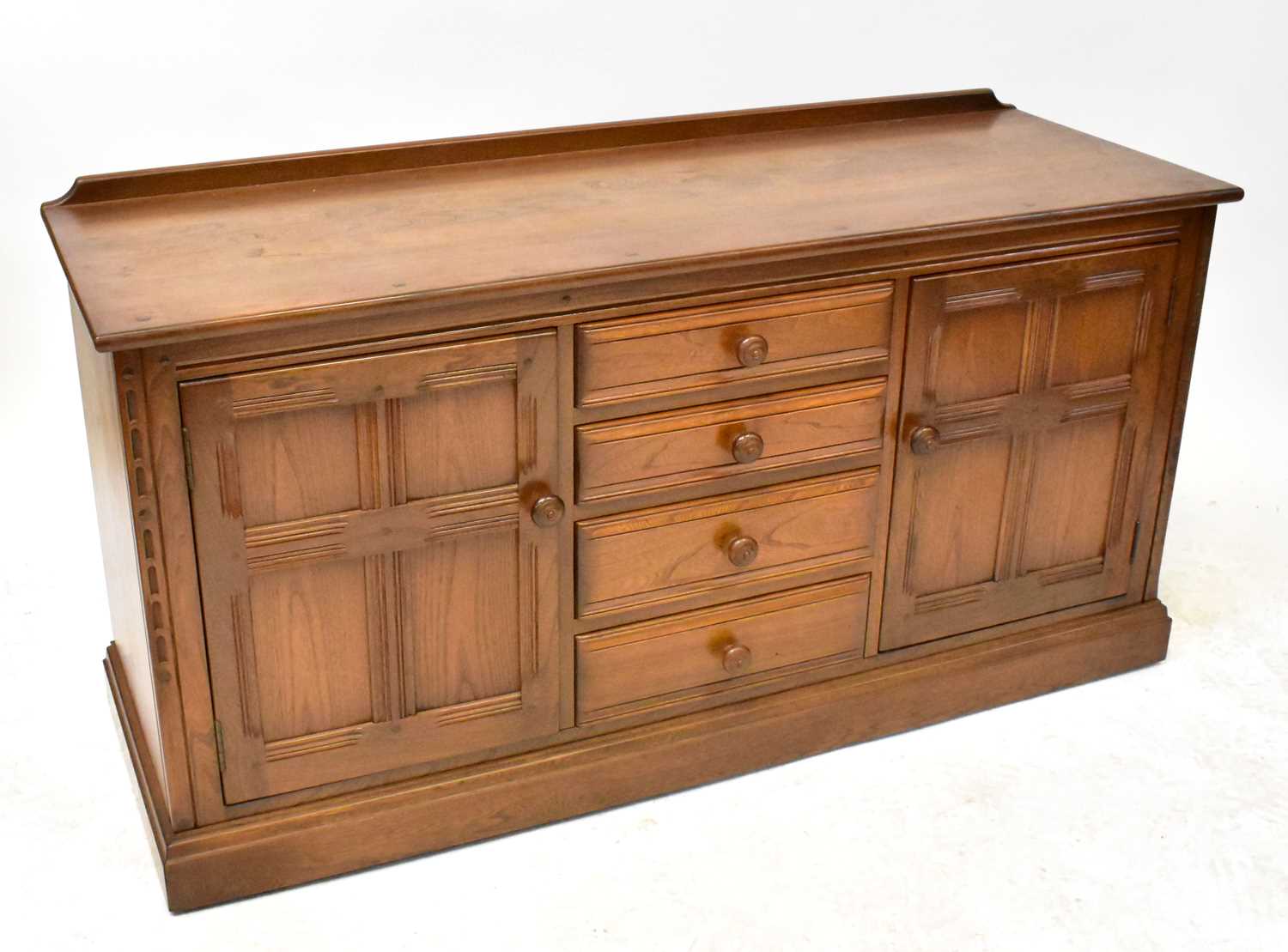 Lot 4 - ERCOL; a mid-colour elm sideboard, comprising...