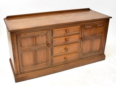 Lot 4 - ERCOL; a mid-colour elm sideboard, comprising...
