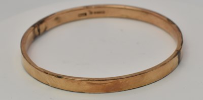 Lot 443 - A 9ct yellow gold rigid bangle, diameter 7.5cm,...