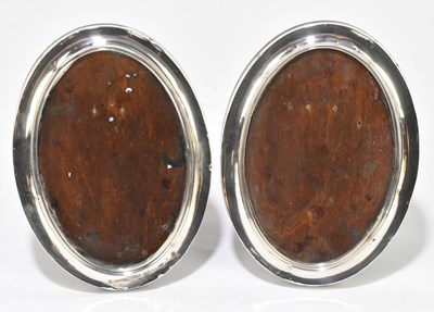 Lot 1179 - SANDERS & MACKENZIE; a pair of George V hallmarked silver mounted easel  back photograph frames