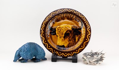 Lot 695 - A stoneware sculpture of an armadillo covered...