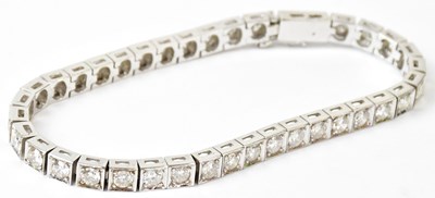 Lot 780 - An 18ct white gold tennis bracelet with square...